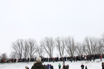 Auf der mit Schnee bedeckten Deichkrone stehen die Schaulustigen